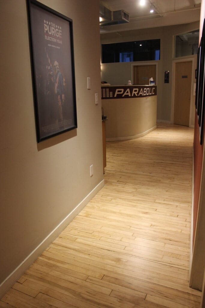 Hallway with wooden floor and movie poster.