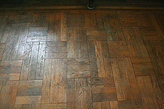Before hardwood floor cleaning in Manhattan showing heavy dirt, grime buildup, and dull wood floor finish